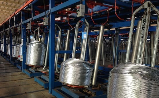Interior of galvanised steel factory and rows of coiled steel