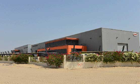 Exterior of grey industrial building in the middle east with sand arround it